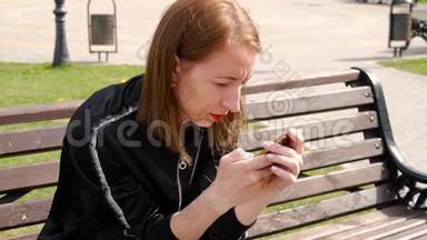年轻漂亮的女人在公园的手机上拨一条<strong>短信</strong>。 大学女生<strong>短信</strong>手机侧视图